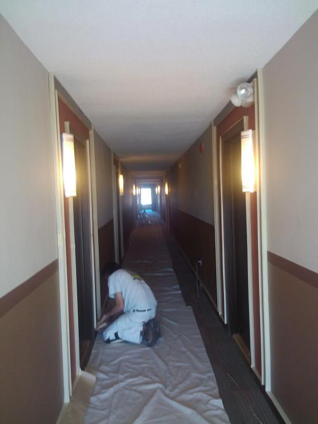 McCABE PAINTING contractor painting an interior hallway.