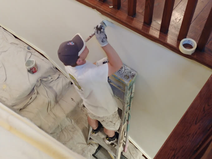 McCABE PAINTING contractor painting an interior staircase wall.